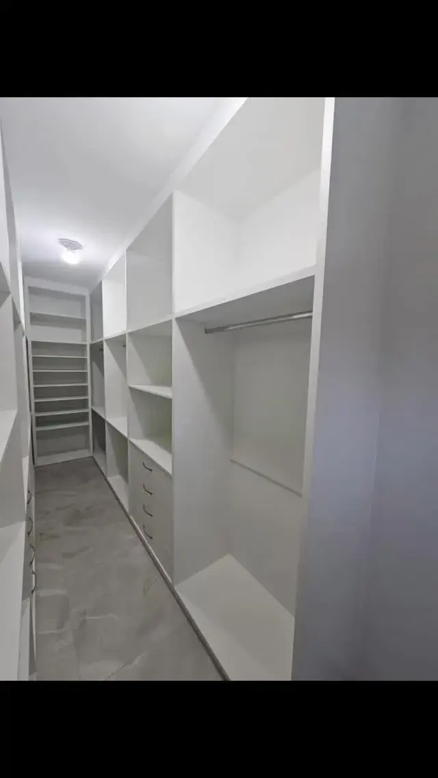 Closet planejado em U no quarto, branco com prateleiras e gavetas, projeto Silva Lima Planejados em Santa Luzia